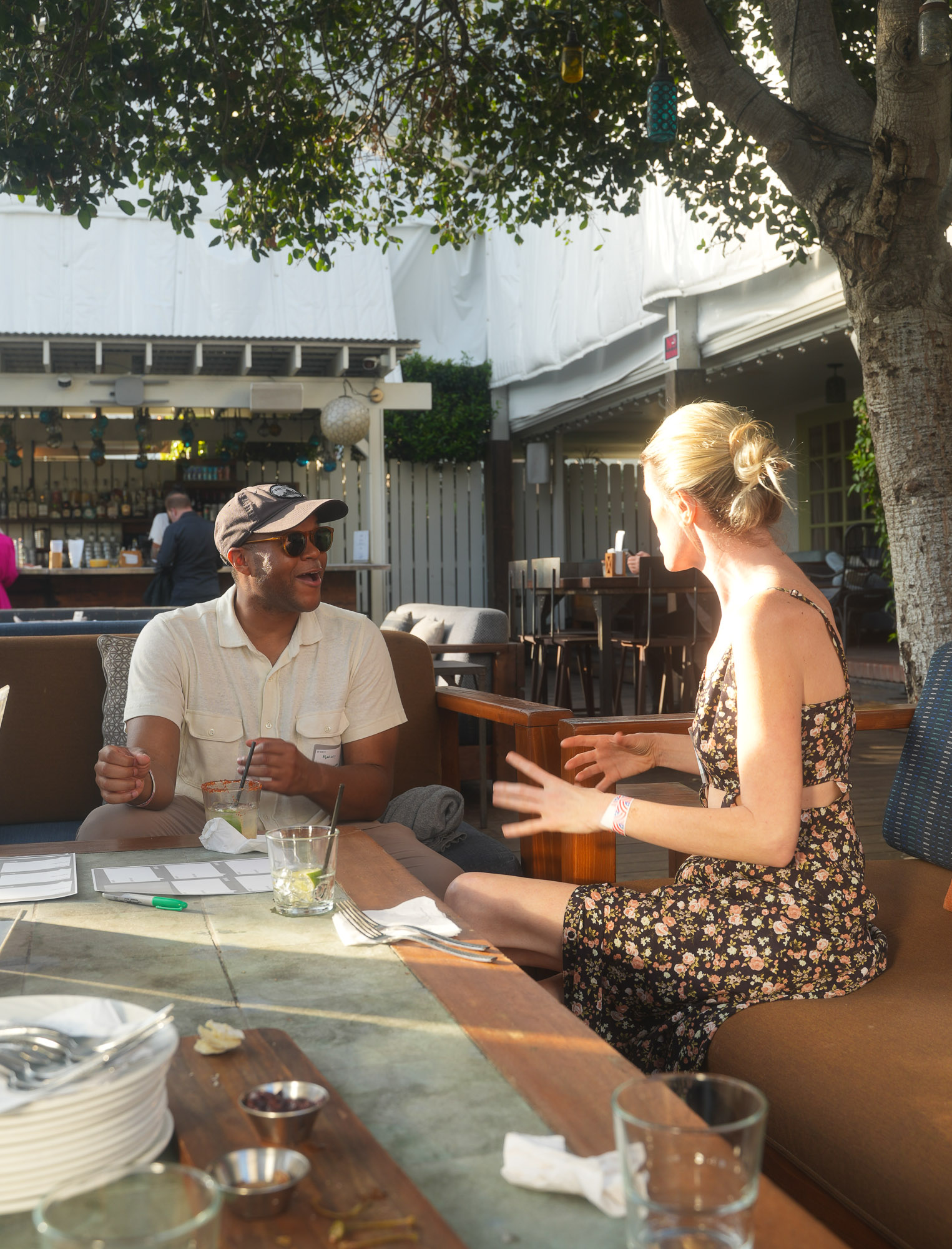Two attendees talking with drinks on the patio