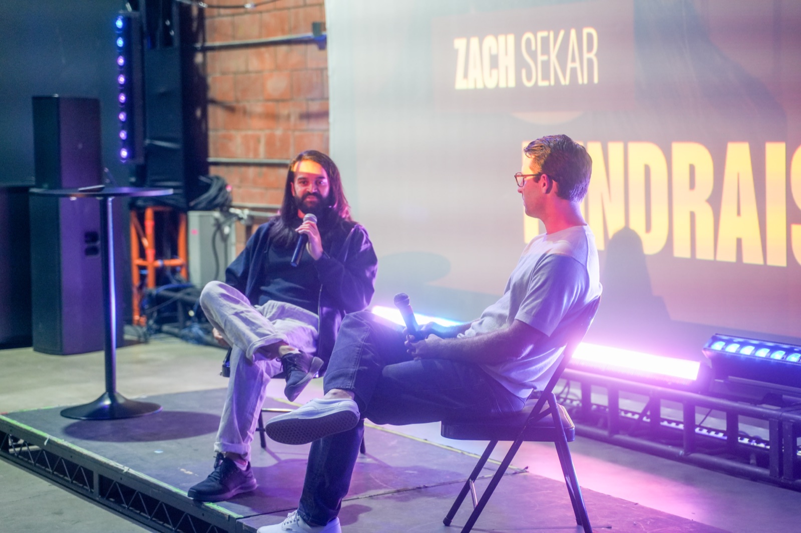 Fireside chat on the Startup Arena stage, two speakers seated under red and purple lights